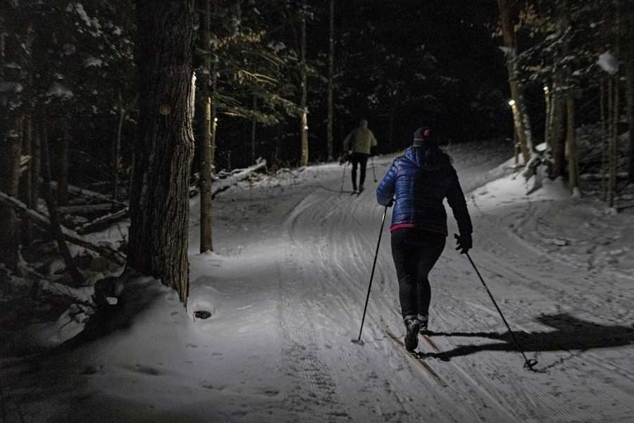 Liza Frenette (right) and John Gillis ski the James C. Frenette Sr. Recreation Trails in Tupper Lake at night