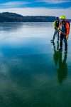 Dan Spada, John Rosenthal, and Dave Phillips are pictured skating across a blue and icy Lake Champlain off Fort Ticonderoga in helmets, vests and other gear.