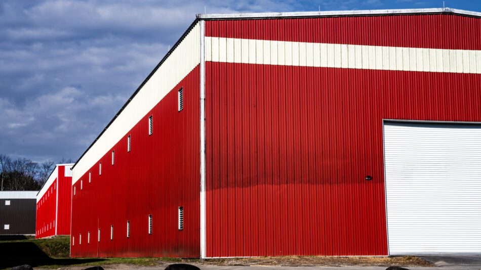 One of the distillery buildings at Whistle Pig in Mineville, with a new building behind it. It appears that the bottom of the building has been cleaned.