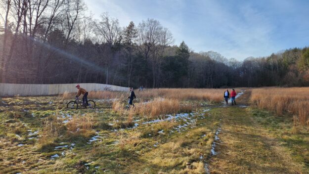 people walking and biking in a field