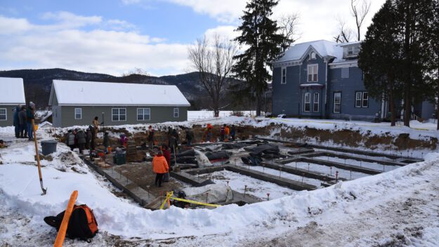 A dig site in the snow with volunteers