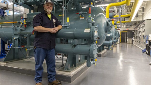 man in front of green machine