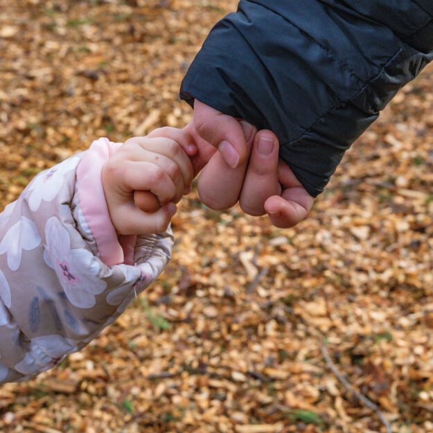 child holding hands with an adult