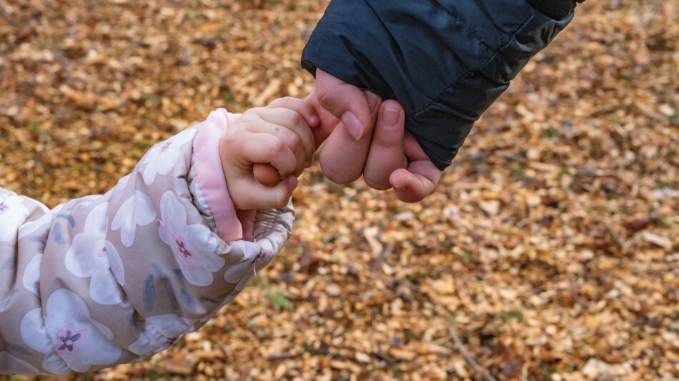 child holding hands with an adult