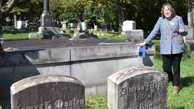 a woman walking by historic grave stones