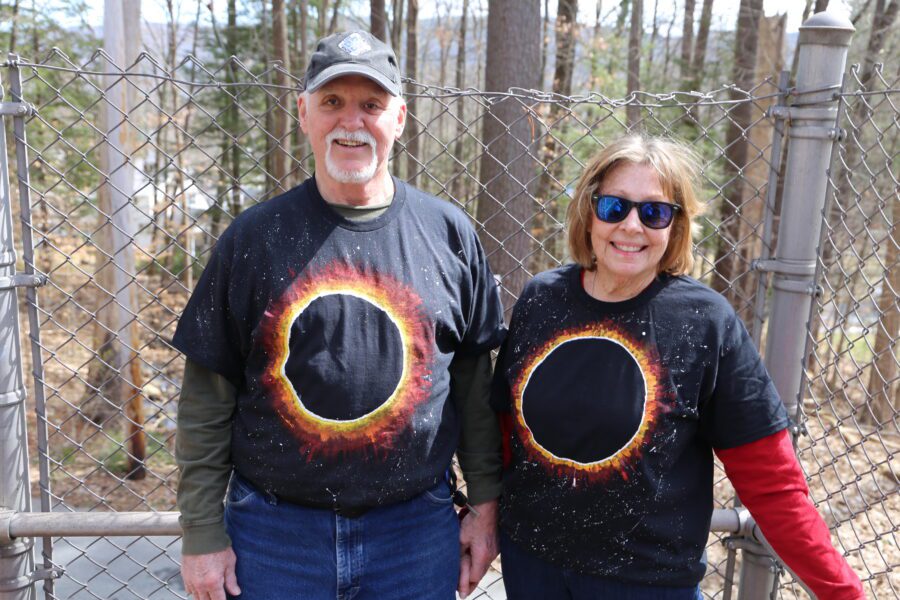 Lake George residents Peter and Joyce Hawthorne stood on the bridge over the Northway that leads to Prospect Mountain in Lake George, waving to cars as they passed below. They wore homemade t-shirts depicting a solar eclipse.