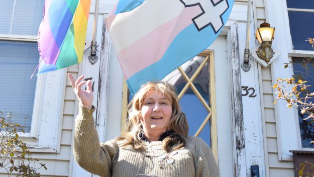 LGBTQ activist Kelly Metzgar stands with her Pride flags.