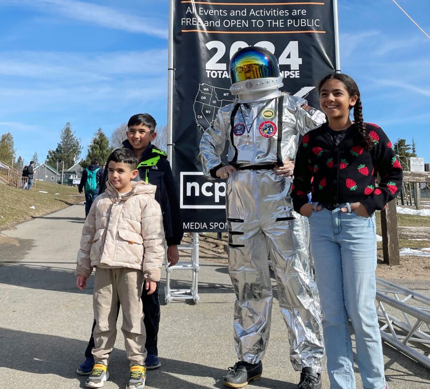 children posing with astronaut during tupper lake eclipse event