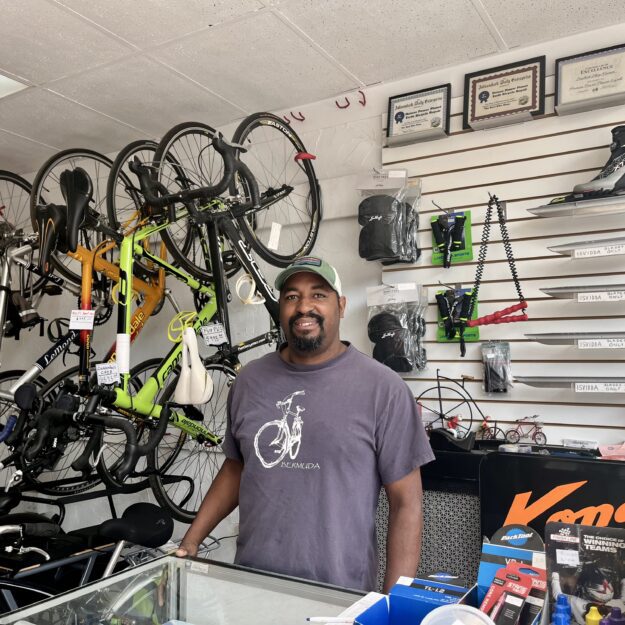 A man stands behind the counter of a bike shop in Saranac Lake, New York.