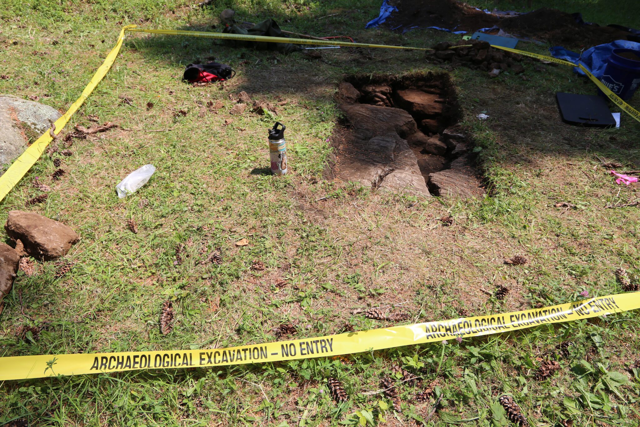 An archaeological test pit is cordoned off at the Lake George Battlefield Park