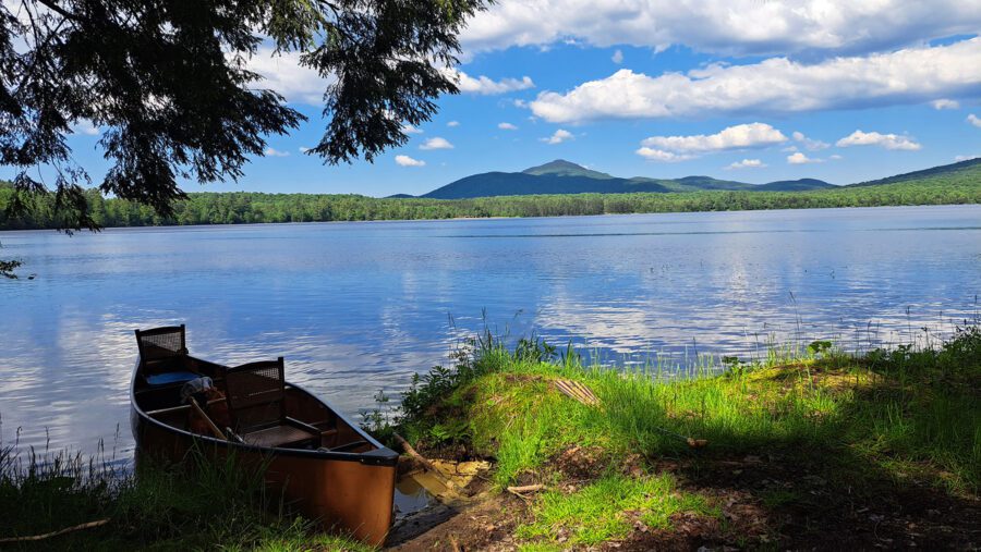 Canoe on a grassy lakeshore.