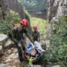 Rangers Charlie Foutch, top and Andrew Lewis, assist an injured hiker down the Trap Dike at Avalanche Lake on Mount Colden in July 2023