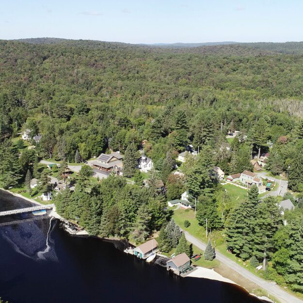 Aerial shot of a river with a white footbridge across it