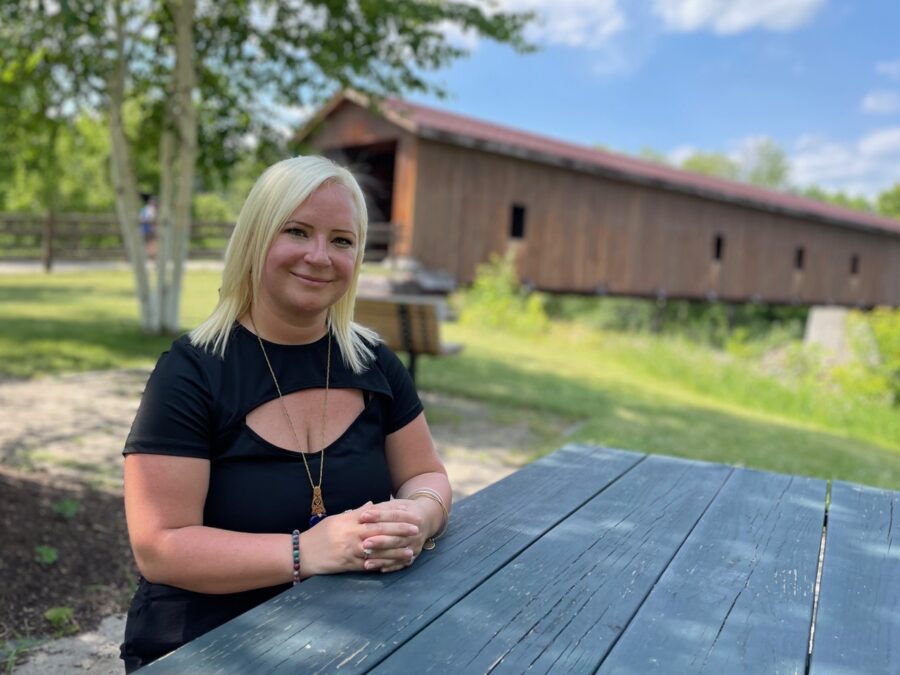 Job recruiter Gabrielle Neidlinger wearing a black shirt, sitting at a picnic table