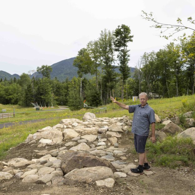 Kris Cheney-Seymour, program manager at Mount Van Hoevenberg, describes how mountain bikers will go through this rock garden. Photo by Mike Lynch