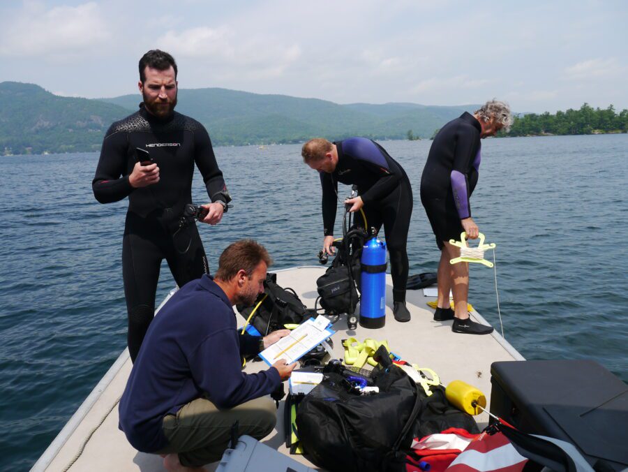 group in wet suits ready to dive into Lake George to look for milfoil