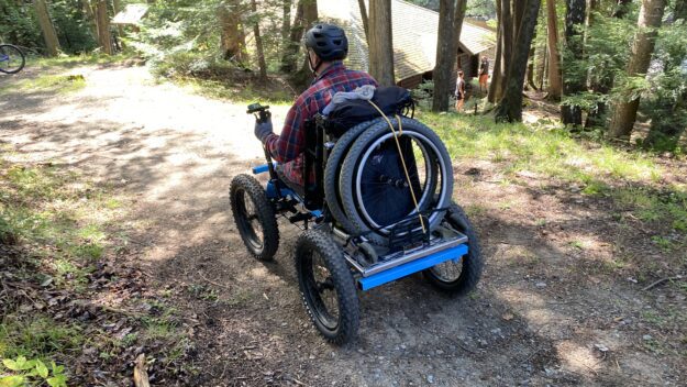 DEC/APA Accessibility Advisory Committee member Scott Remington rides quadracycle at Great Camp Santanoni.