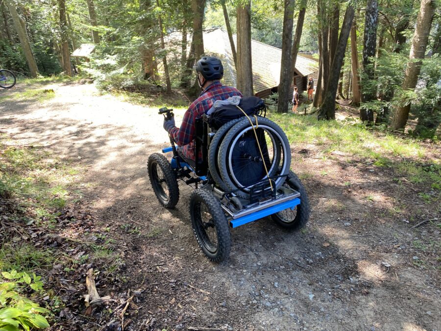 DEC/APA Accessibility Advisory Committee member Scott Remington rides quadracycle at Great Camp Santanoni.