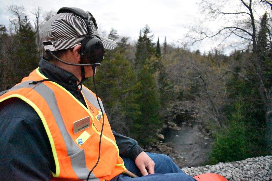 Rail worker overlooks a creek.