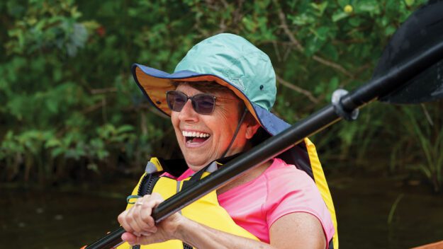 smiling woman in a kayak part of the ladies of the lake group