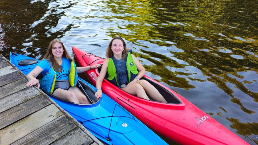 two young women in kayaks at the one square mile of hope event in inlet