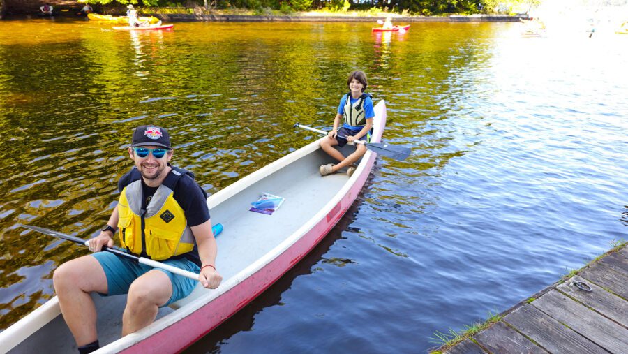 two young men in a canoe at the one square mile of hope event in inlet