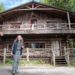 Woman in front of a wooden camp