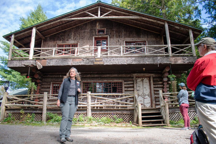 Woman in front of a wooden camp