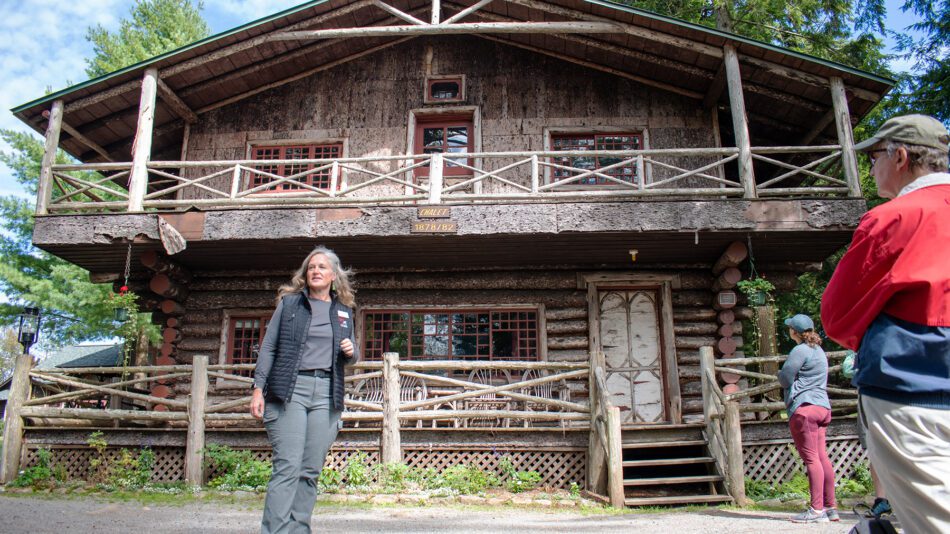 Woman in front of a wooden camp