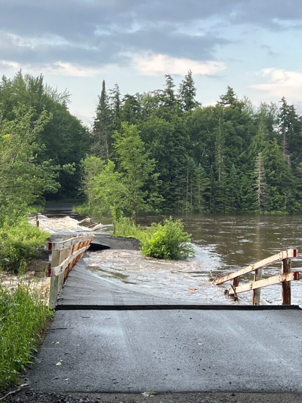 A broken bridge in high waters in the Adirondacks