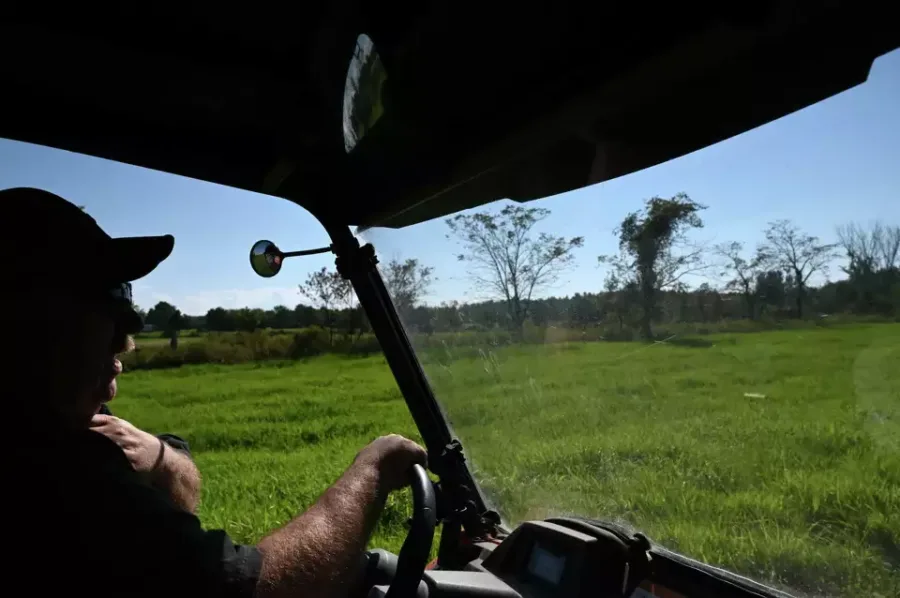 man driving car in a field near the Canadian border